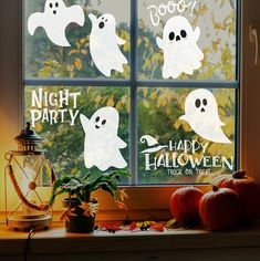 halloween window stickers with ghost and pumpkins on the windowsill in front of a window