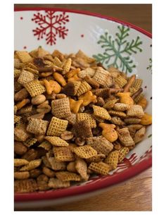 a bowl filled with chex mix on top of a wooden table