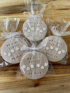 four cookies wrapped in clear cellophane with white flowers on the front and back