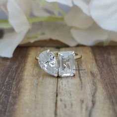 two engagement rings sitting on top of a wooden table