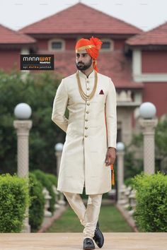 a man in a white suit and orange turban