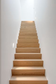 a set of wooden stairs leading up to a white wall