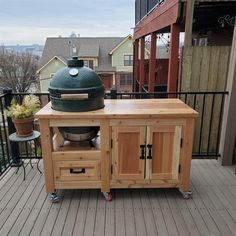 a big green egg sitting on top of a wooden table