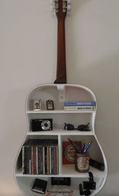 a guitar shaped shelf with books and other items