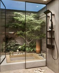 a bathroom with a large glass shower and a tree on the wall next to it