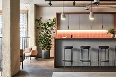 an office with three bar stools and two planters