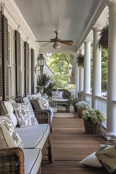 the front porch is lined with wicker furniture and plants on either side of it