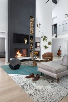 a living room with a fireplace, couches and rugs on the floor in front of it