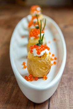 small appetizers are arranged on a white plate with red and orange confetti