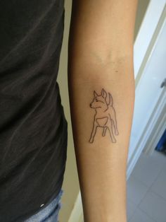 a woman's arm with a tattoo on it that has a dog in the middle