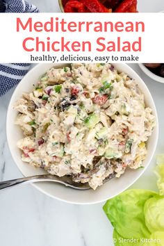 a white bowl filled with chicken salad next to lettuce and tomatoes