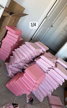 a pile of pink boxes sitting on top of a floor next to a closet door