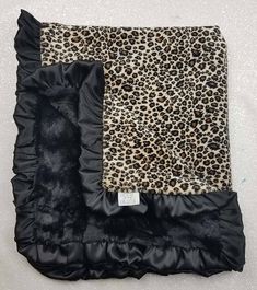 the leopard print and black satin blanket is on display