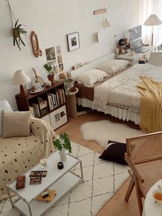 a bed room with a neatly made bed sitting next to a table and two chairs