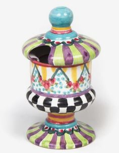 a multicolored ceramic jar with a lid on it's stand, decorated with flowers and stripes