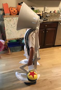 a young boy is using a giant megaphone on top of a ball in the kitchen