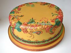 a decorated cake sitting on top of a yellow plate with red and green trimmings