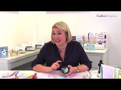 a woman sitting at a table in front of a printer and other crafting supplies