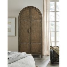 a large brown cabinet sitting in a bedroom next to a window