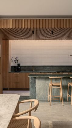 a kitchen with an island counter and stools next to it in front of a bar