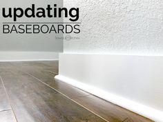 an updating baseboard in a room with white walls and wood flooring on the side