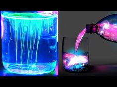 a bottle pouring water into a glass filled with blue and pink liquid next to a lit up vase