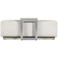 a white couch with a metal frame on the top and bottom end, sitting in front of a white background