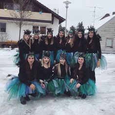 a group of women dressed up in costumes posing for a photo on the snow covered ground