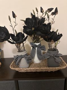 two vases with flowers in them sitting on a table next to a stuffed animal