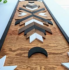 a wooden table topped with different types of scissors and cutting board cut out into an arrow shape