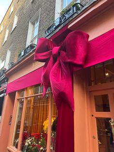 a large pink bow on the side of a building