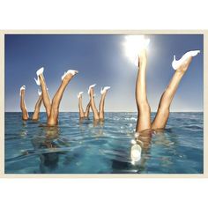 the woman is floating in the water with her legs up and their hands out to each other