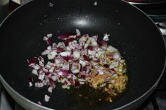 onions being cooked in a frying pan on top of the stove with other cooking ingredients