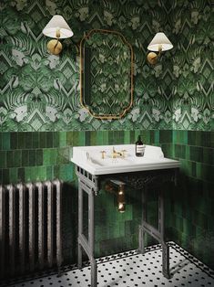 a bathroom with green tiles and gold fixtures on the wall, along with a pedestal sink