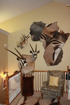 a living room filled with furniture next to a wall mounted antelope on the wall