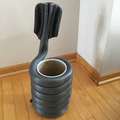 a large gray vase sitting on top of a wooden floor