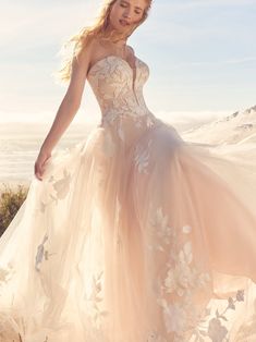 a woman in a wedding dress standing on the beach