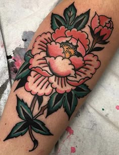 a woman's arm with a flower tattoo on it