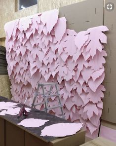 a room with pink paper on the wall and a ladder in front of it that is being worked on