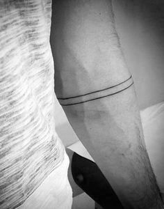 black and white photograph of a man's arm with a line tattoo on it