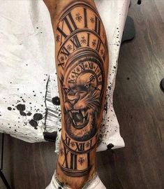 a man's leg with a clock tattoo on it and a lion head in the middle