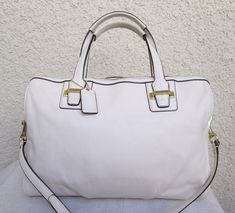 This cool white leather vintage Coach satchel/shoulder bag is in MINT NEW condition.  black piping trim on the edges and brass hardware.  zip top, one large pocket with smaller zip and cellphone pockets inside.  champagne satin interior. Coach White Leather Bag, Chic White Satchel With Metal Hardware, White Shoulder Bag With Metal Hardware For Everyday, White Shoulder Bag With Metal Hardware For Office, White Leather Satchel With Metal Hardware, White Satchel With Metal Hardware For Travel, White Office Bag With Metal Hardware, White Tote Shoulder Bag With Metal Hardware, White Shoulder Bag With Metal Hardware For Travel