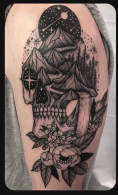 a black and white skull with flowers on it's arm, sitting in front of a