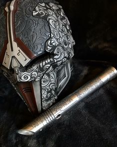 a pen sitting on top of a black cloth next to a silver and brown object