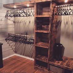 a wooden shelf with several pairs of shoes hanging on it's sides in a walk - in closet