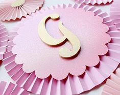 pink and gold paper fans with the letter c on them