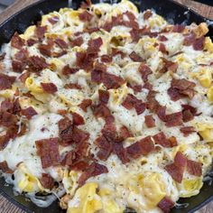 a skillet filled with macaroni and cheese covered in bacon