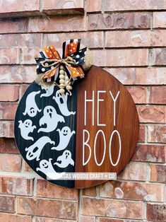 a sign on the side of a brick building that says hey boo with ghost decorations