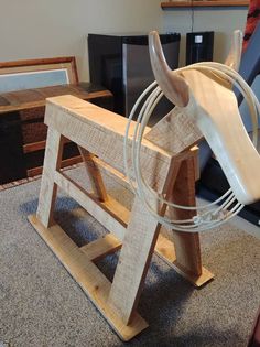 a wooden horse sculpture sitting on top of a floor