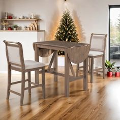 a dining room table with two chairs and a christmas tree in the corner behind it